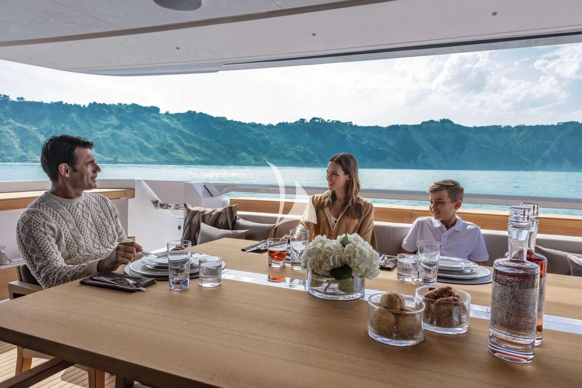 a group of people sitting at a table outside aboard ALVIUM Yacht for Sale