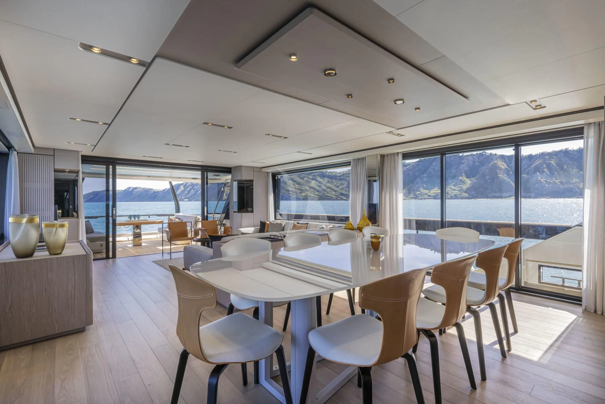 a room with tables and chairs aboard H&CO Yacht for Sale