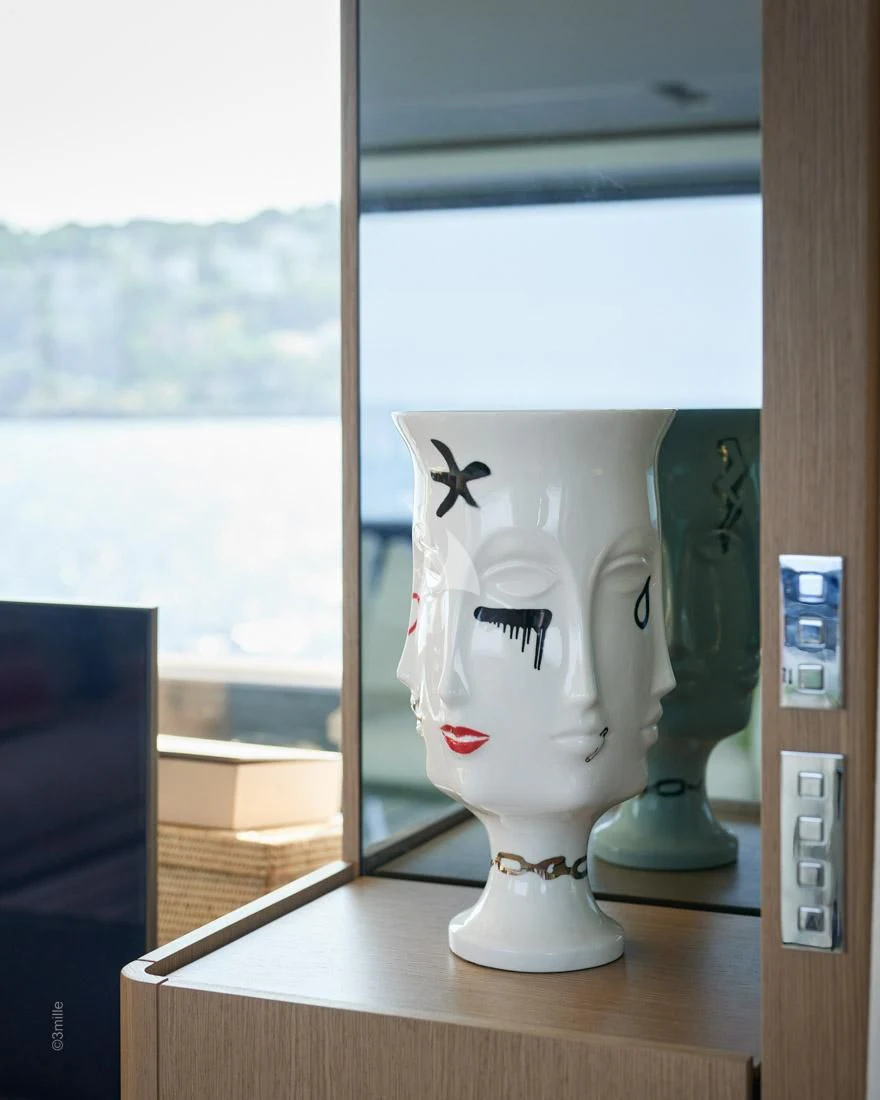 a white vase with a face on it aboard H&CO Yacht for Sale