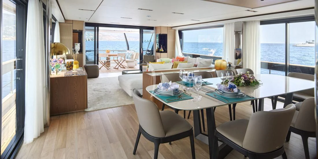 a dining room with a large window aboard H&CO Yacht for Sale