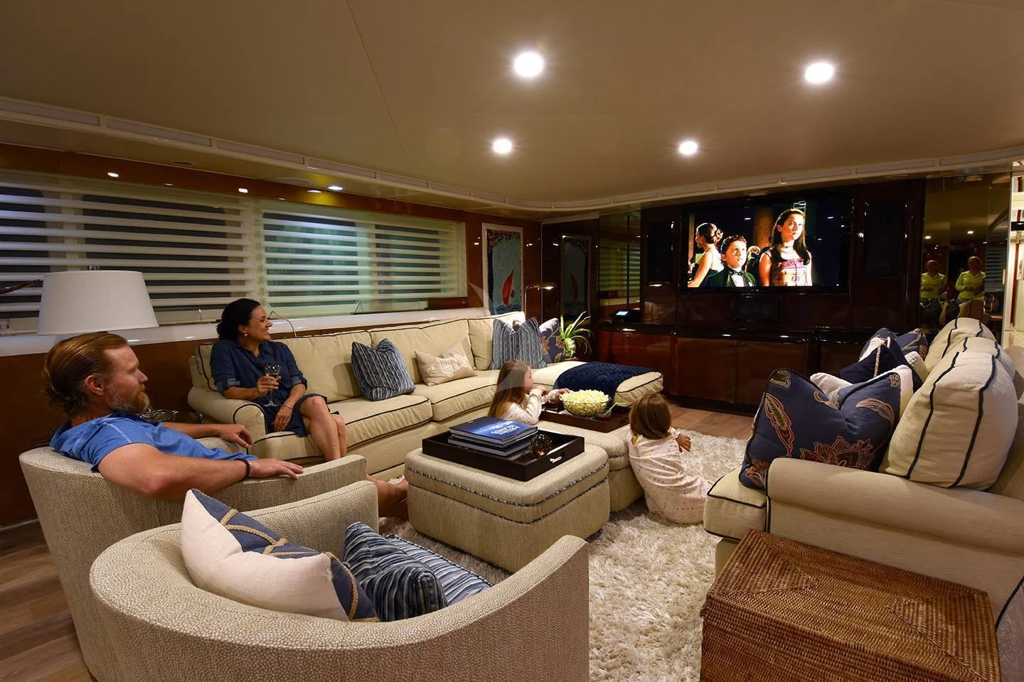 a group of people sitting on a couch watching a television aboard BIG EAGLE Yacht for Sale