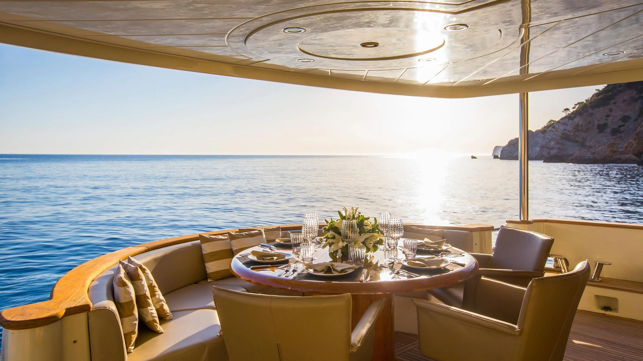 a table and chairs on a balcony overlooking the ocean aboard SERAPH PRIMERO Yacht for Sale