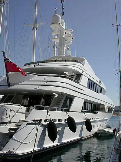 a white yacht with a red and black flag on the front aboard VITA NOVA Yacht for Sale