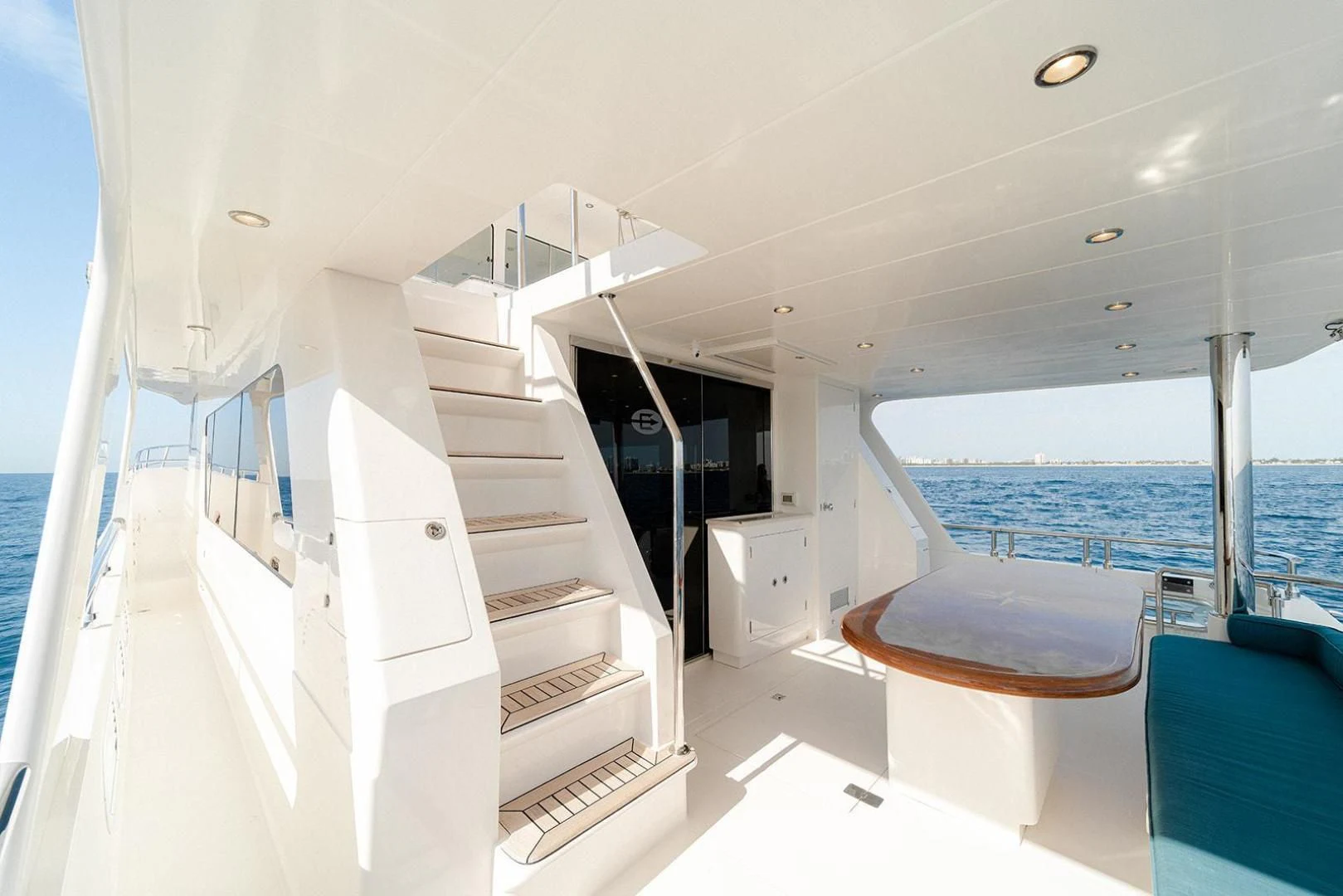 a white room with a table and a staircase aboard DREAM CATCHER Yacht for Sale