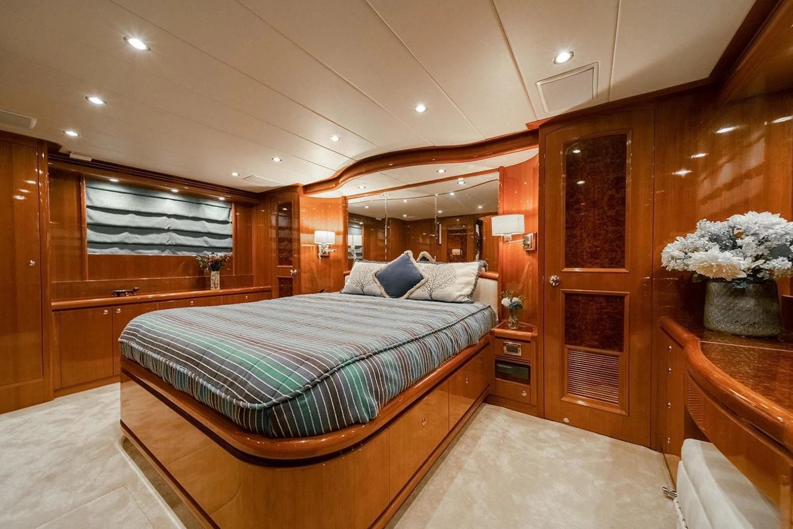 a bedroom with a bed and a wood cabinet aboard DREAM CATCHER Yacht for Sale