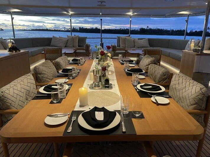 a table with plates and candles aboard JUST B Yacht for Sale