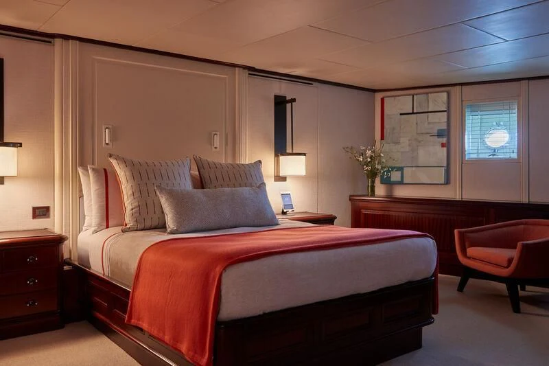 a bedroom with a bed and a desk aboard JUST B Yacht for Sale