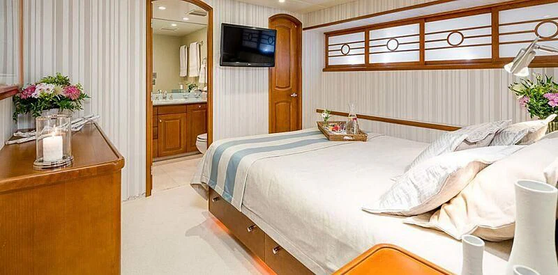 a room with a bed and a television aboard DAYDREAM Yacht for Sale