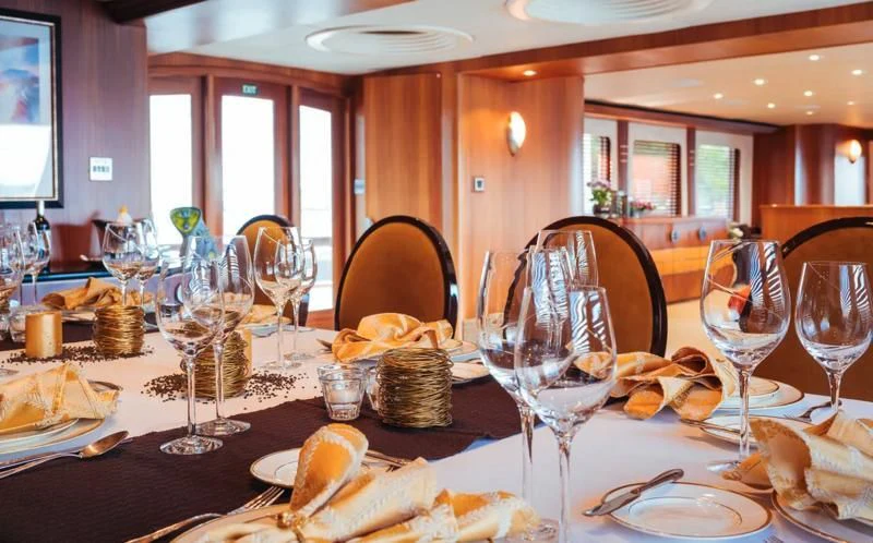 a table with food and wine glasses aboard DAYDREAM Yacht for Sale
