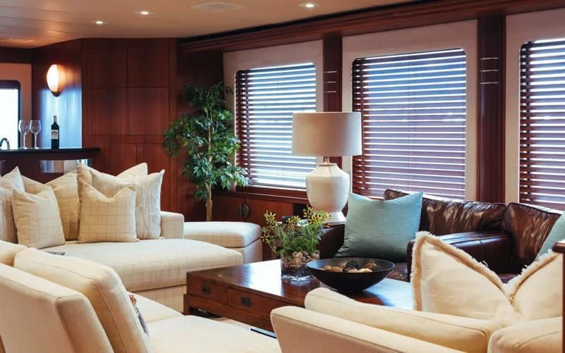 a living room with a couch and a plant in the corner aboard DAYDREAM Yacht for Sale