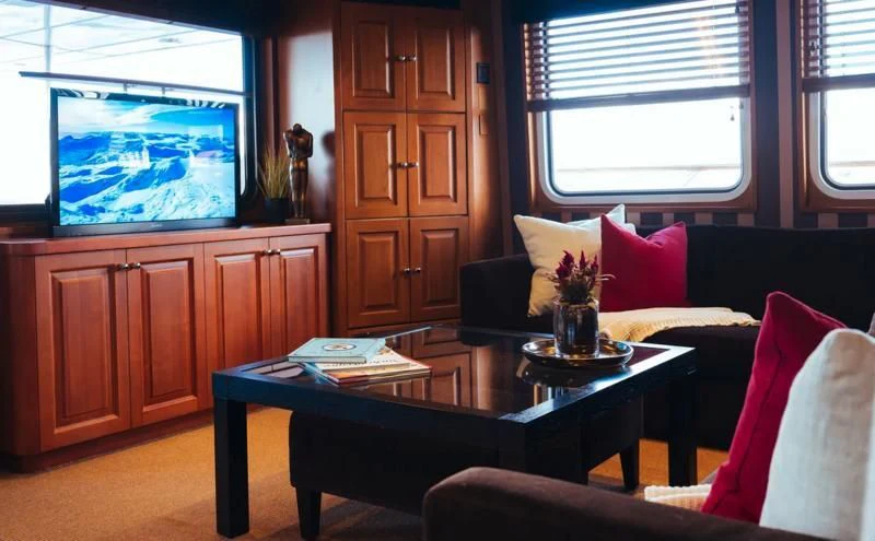 a living room with a table and couches aboard DAYDREAM Yacht for Sale