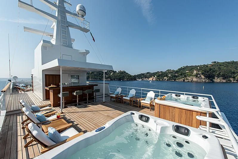 a deck with a pool and a deck with chairs and a deck aboard BLEU DE NIMES Yacht for Charter