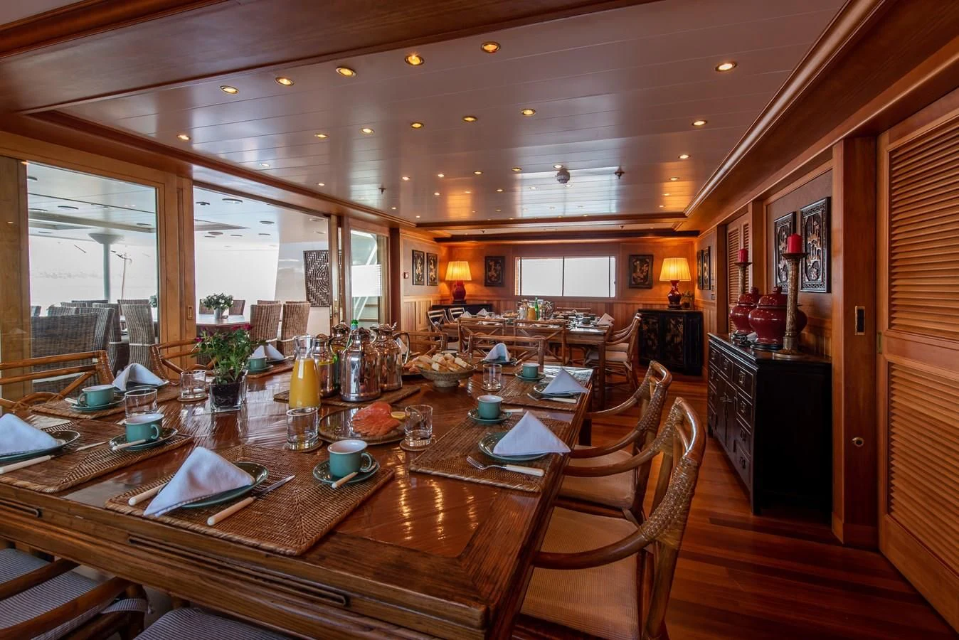 a large dining room with a wood table and chairs aboard BLEU DE NIMES Yacht for Charter