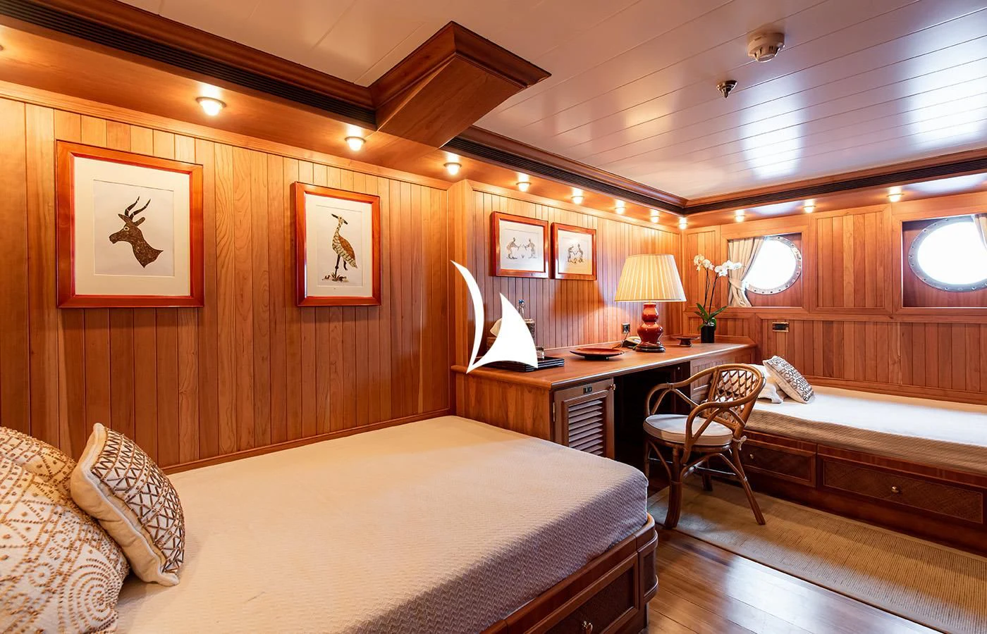 a room with a bed and desk aboard BLEU DE NIMES Yacht for Charter