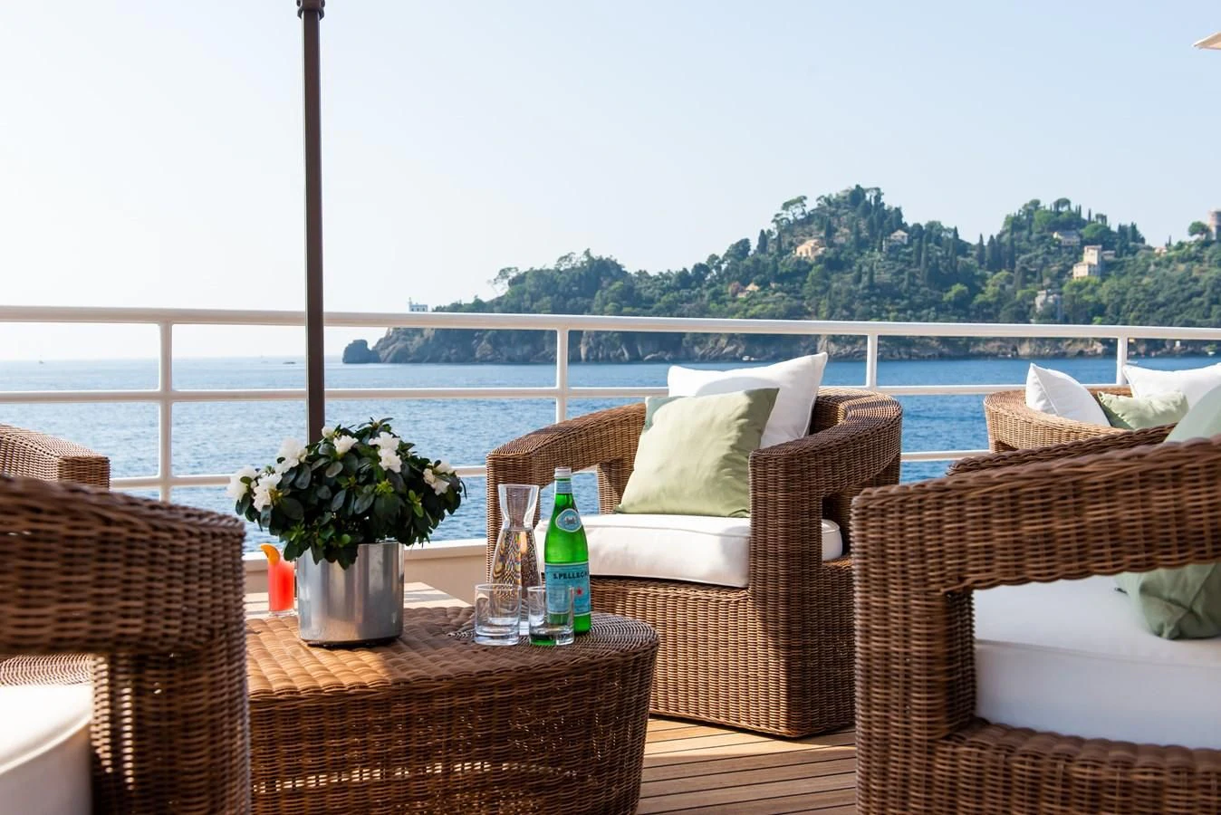 a patio with chairs and a bottle of wine on a deck aboard BLEU DE NIMES Yacht for Charter