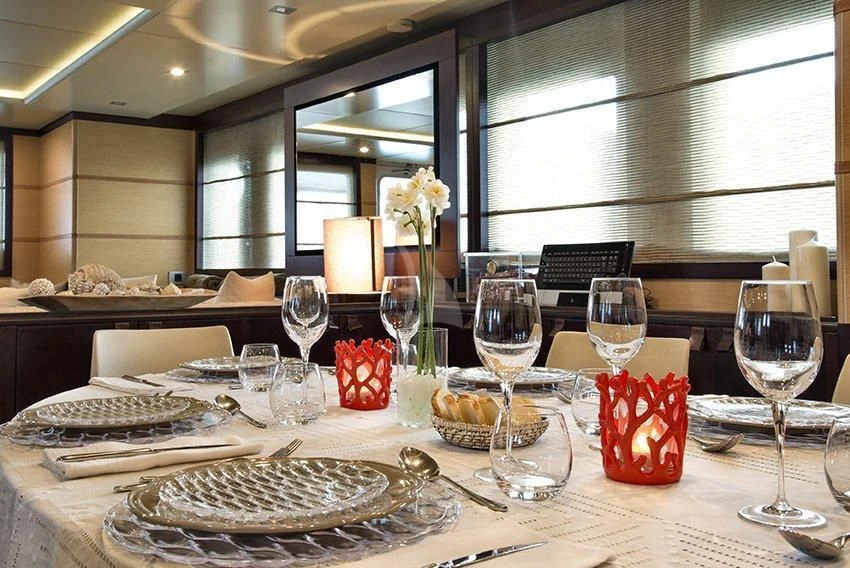 a table with wine glasses and food aboard INDIAN Yacht for Sale