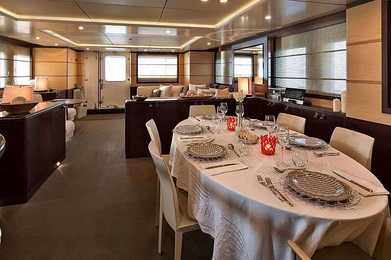 a large room with tables and chairs aboard INDIAN Yacht for Sale