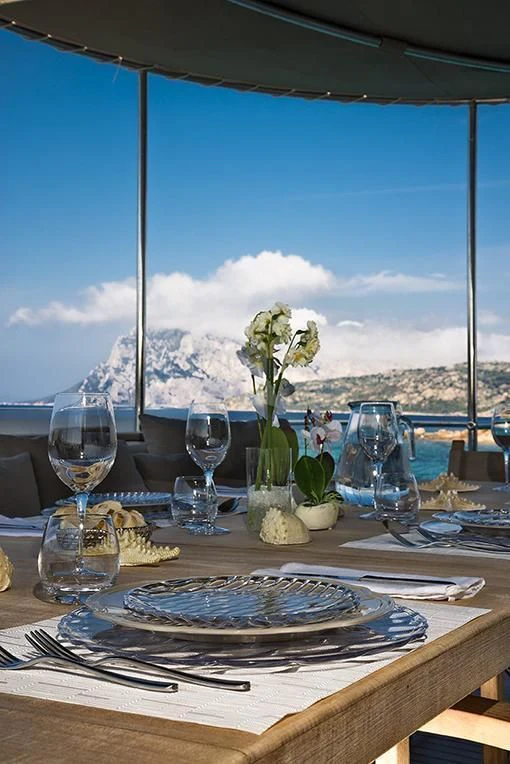 a table with plates and glasses on it aboard INDIAN Yacht for Sale