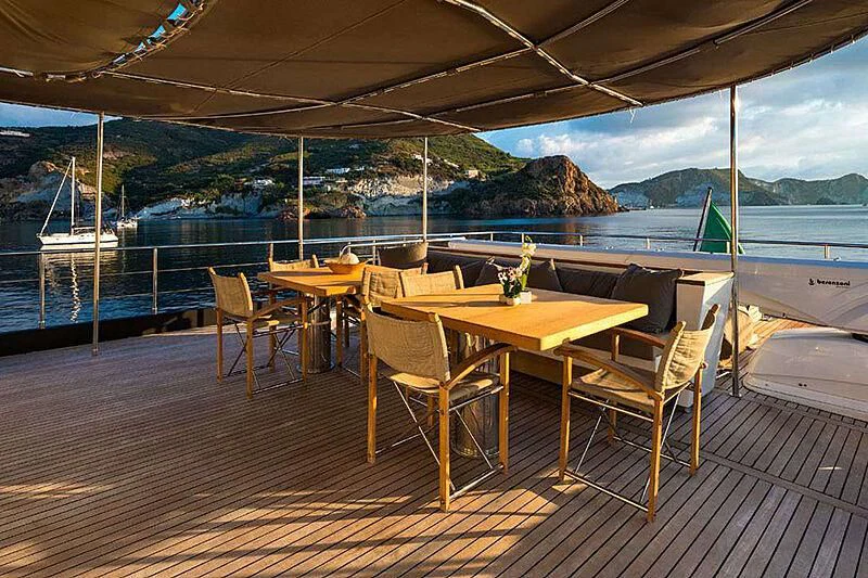 a table and chairs on a deck overlooking a body of water aboard INDIAN Yacht for Sale