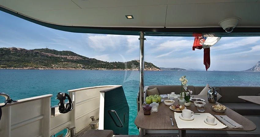 a table with food on it by a body of water aboard INDIAN Yacht for Sale