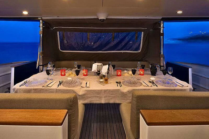 a room with a table and a tv aboard INDIAN Yacht for Sale