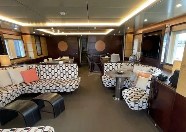 a room with a table chairs and a couch aboard INDIAN Yacht for Sale