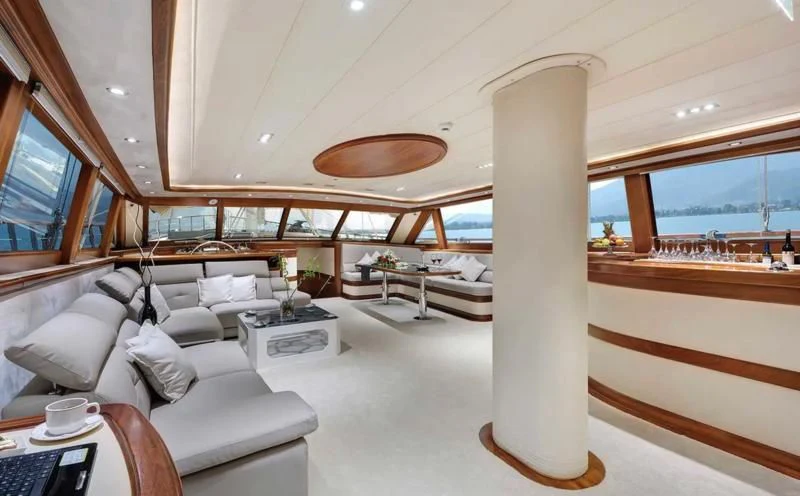 a room with a couch and a table and a large window aboard ALESSANDRO I Yacht for Sale