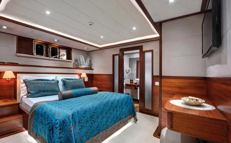 a bedroom with a bed and a table aboard ALESSANDRO I Yacht for Sale