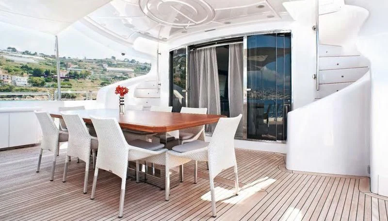 a dining table and chairs in a room with a view of a city aboard TUTTO LE MARRANE Yacht for Charter