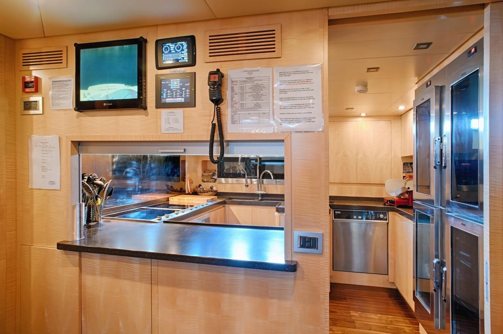 a kitchen with a counter and a television on the wall aboard TUTTO LE MARRANE Yacht for Charter