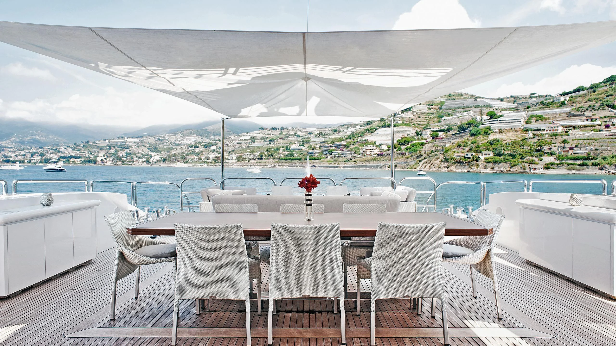 a table set for a meal on a balcony overlooking a large body of water aboard TUTTO LE MARRANE Yacht for Charter