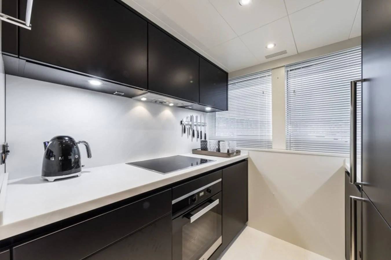 a kitchen with black cabinets aboard BULL Yacht for Sale