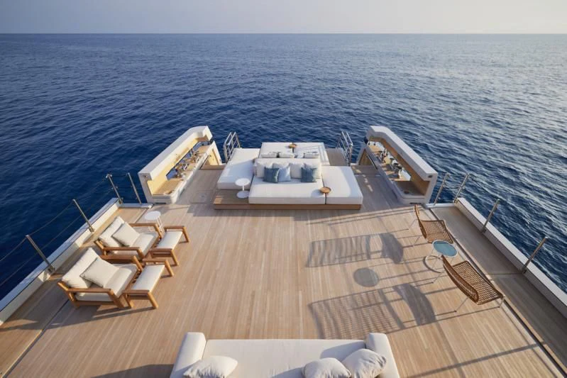 a deck with chairs and tables on it by the water aboard LA LA LAND Yacht for Charter