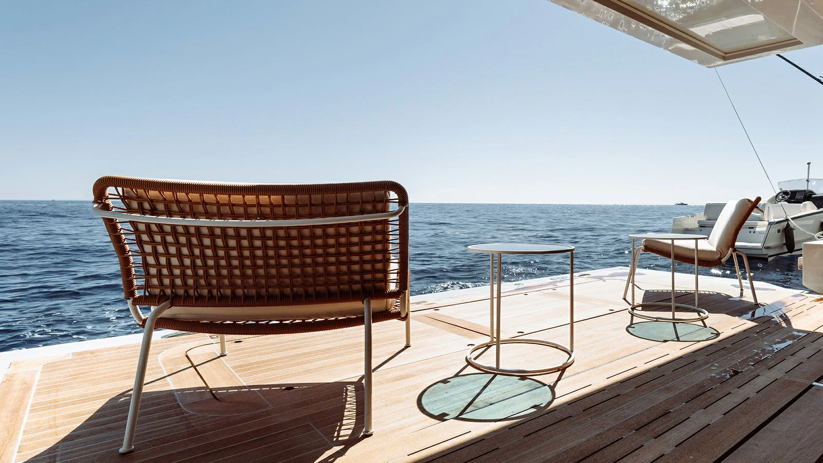 a couple of chairs on a deck overlooking a body of water aboard LA LA LAND Yacht for Charter