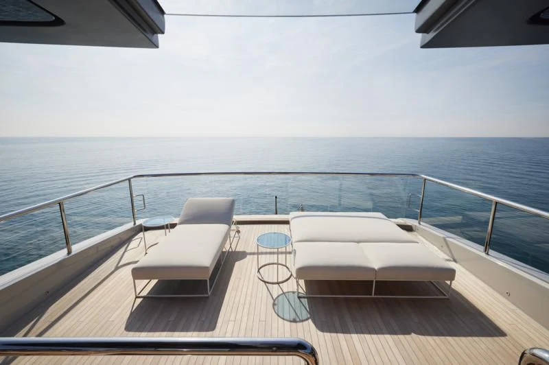 a deck with chairs on it by the ocean aboard LA LA LAND Yacht for Charter