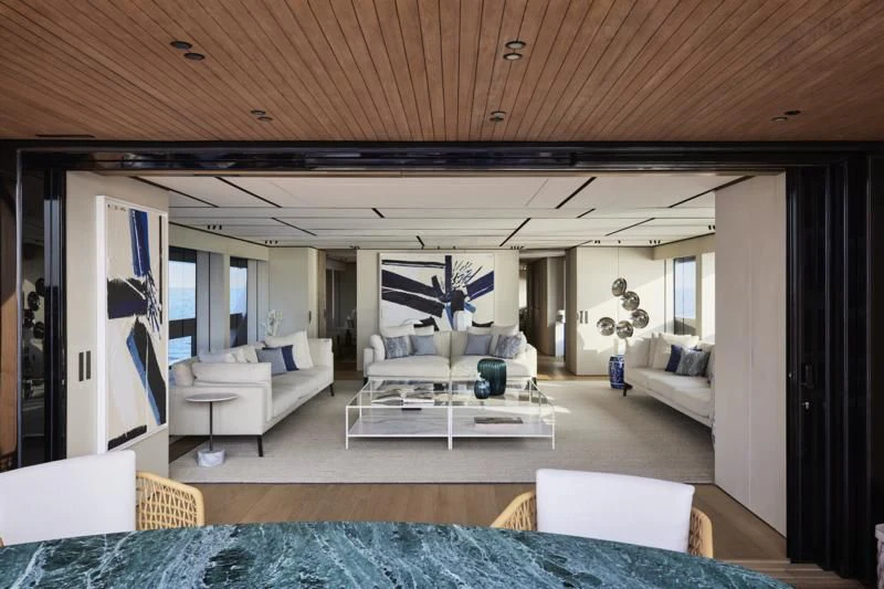 a living room with a large blue rug and white furniture aboard LA LA LAND Yacht for Charter