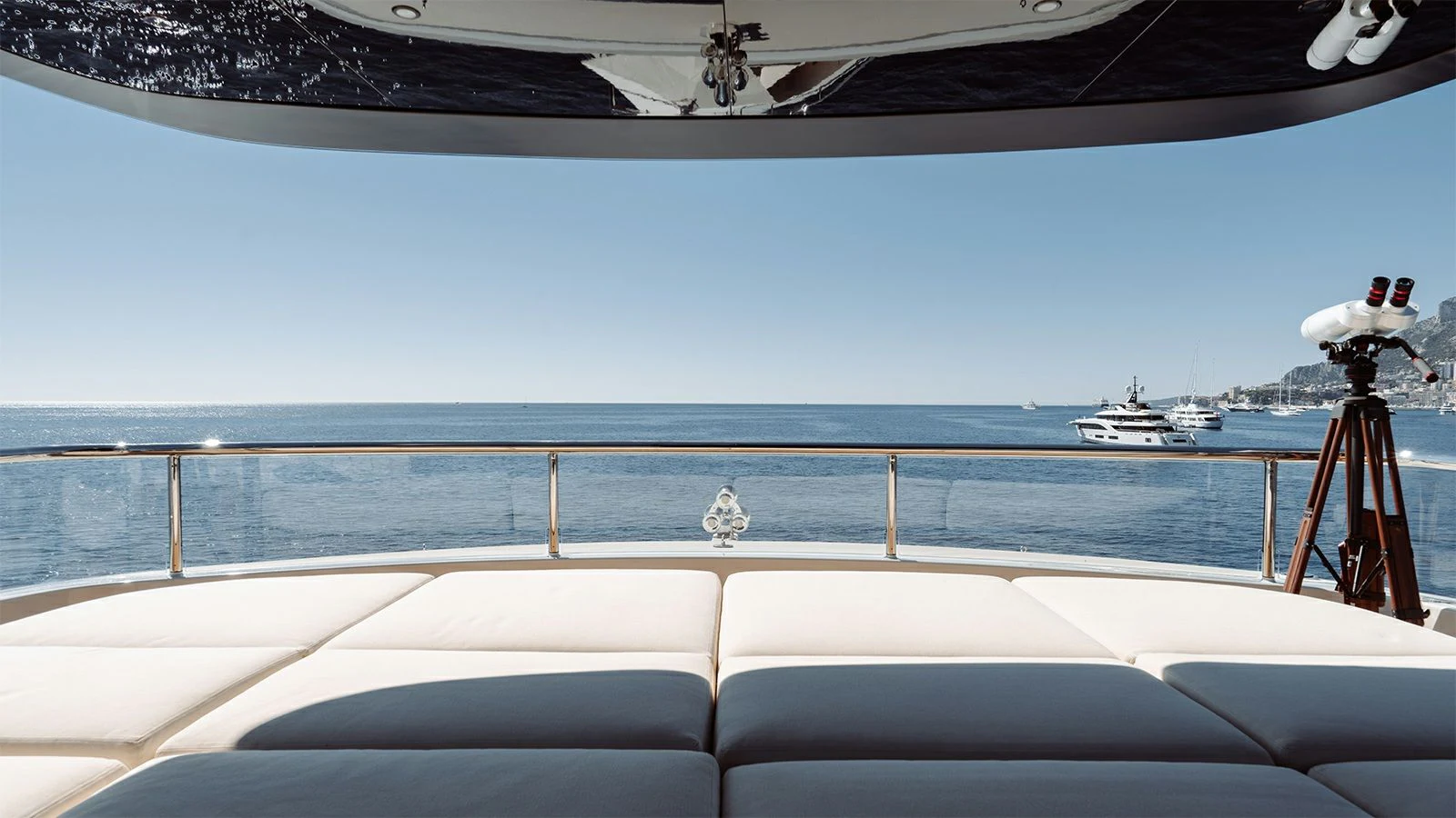 a deck with a railing and a railing with a boat in the background aboard LA LA LAND Yacht for Charter