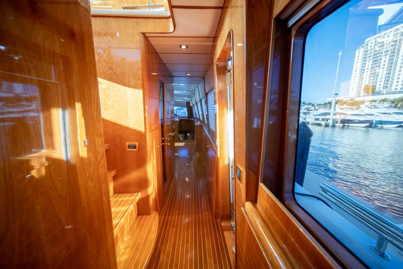 a wooden deck with a view of a city and water aboard HAPPY Yacht for Sale