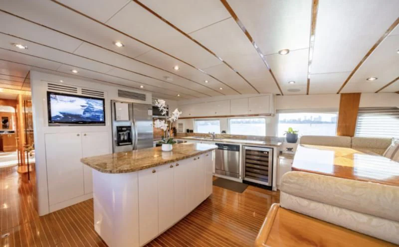 a kitchen with a table and a tv aboard HAPPY Yacht for Sale