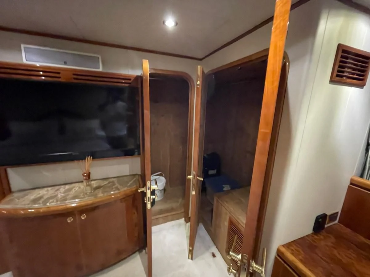 a room with a wood cabinet and a television aboard HAPPY Yacht for Sale