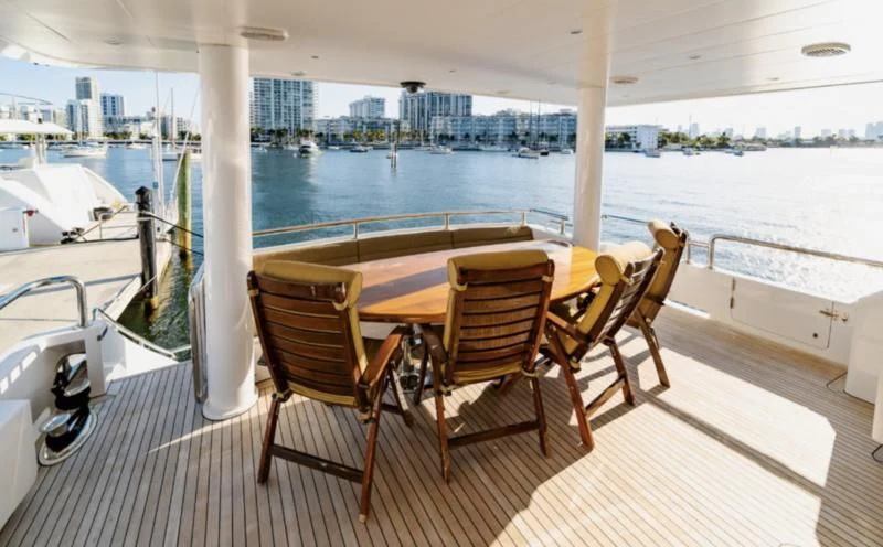 a table and chairs on a deck aboard HAPPY Yacht for Sale