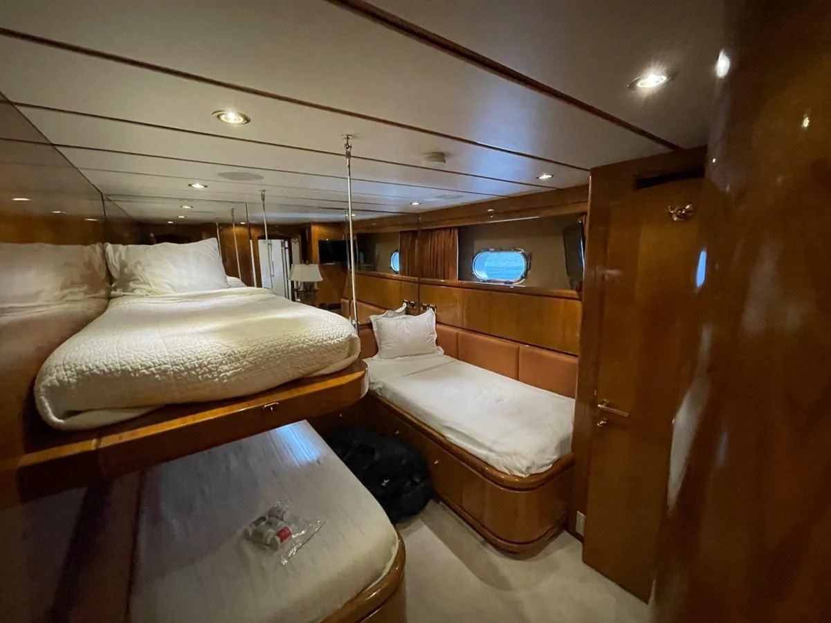 a room with beds and a window aboard HAPPY Yacht for Sale