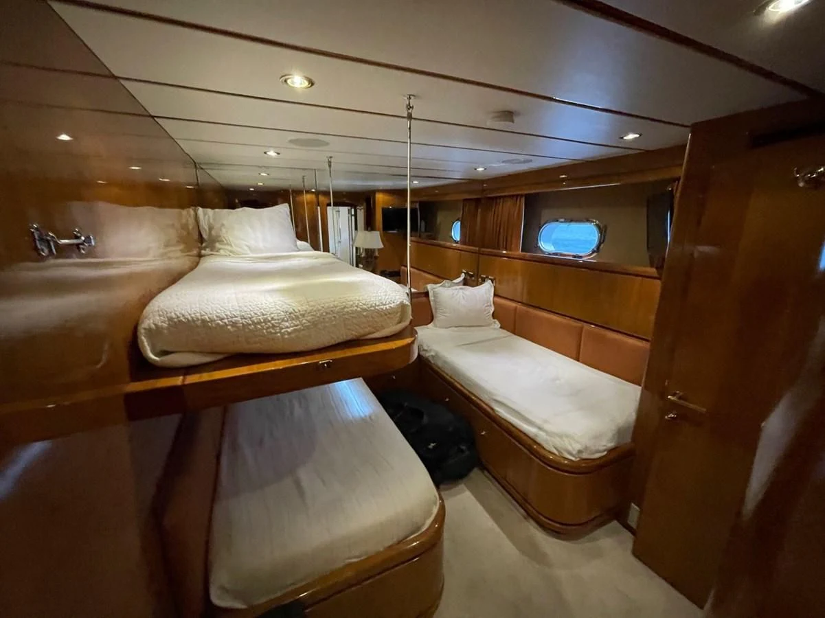 a room with a bed and a chair aboard HAPPY Yacht for Sale