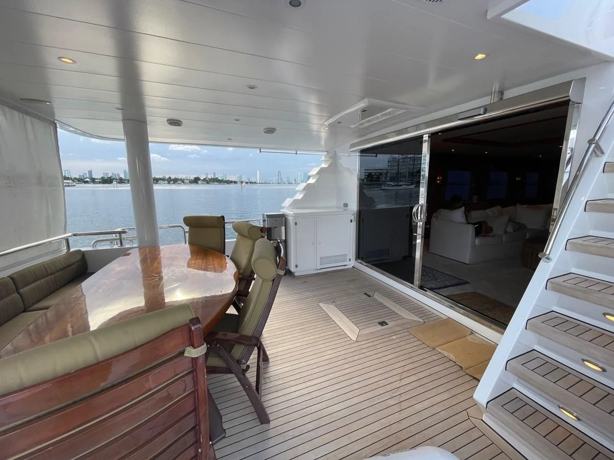 a boat with a table and chairs aboard HAPPY Yacht for Sale