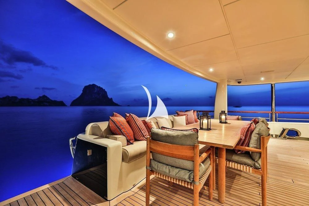 a room with a bed and a table and chairs aboard DENIKI Yacht for Sale