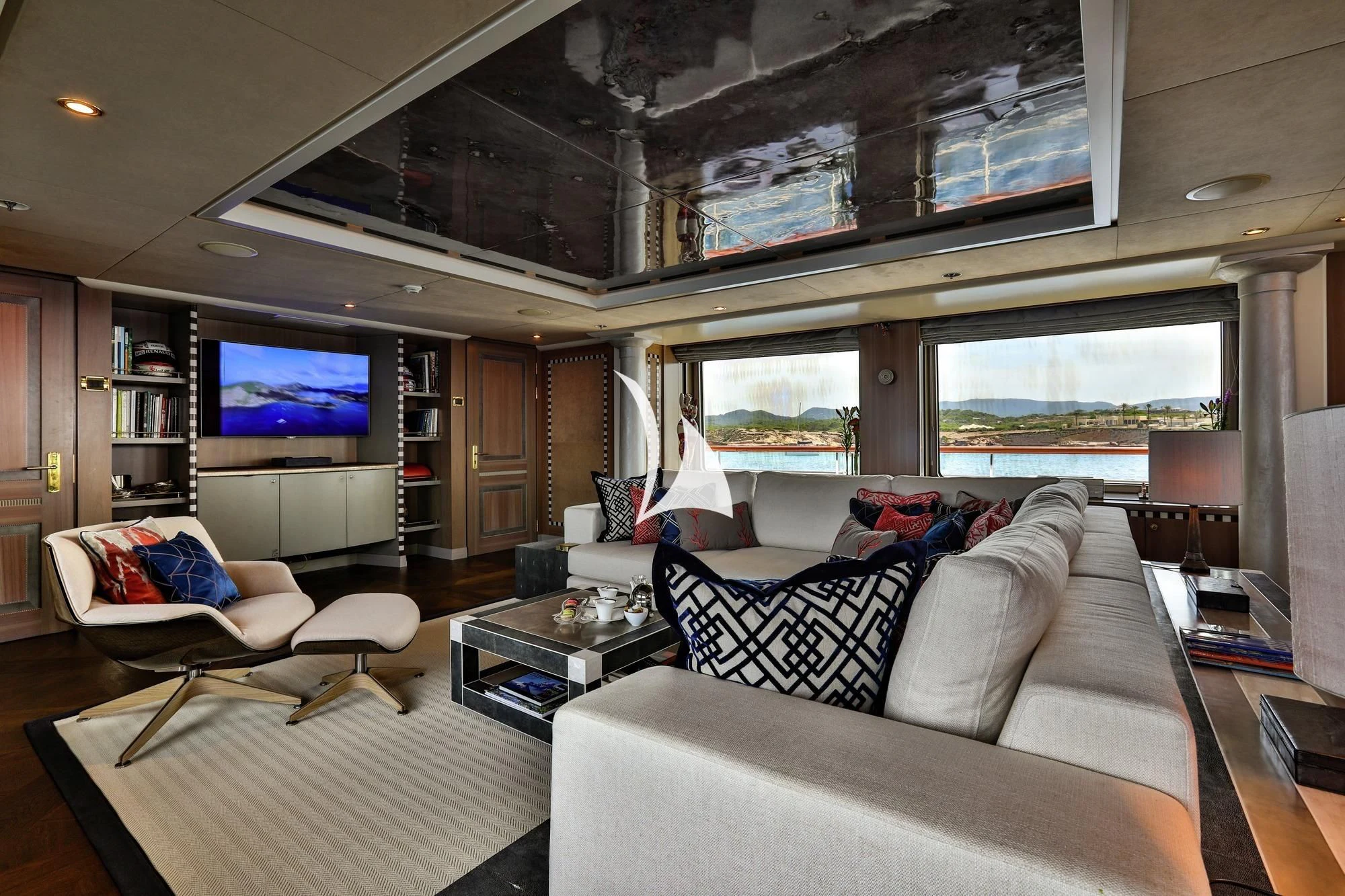 a living room with a large screen aboard DENIKI Yacht for Sale