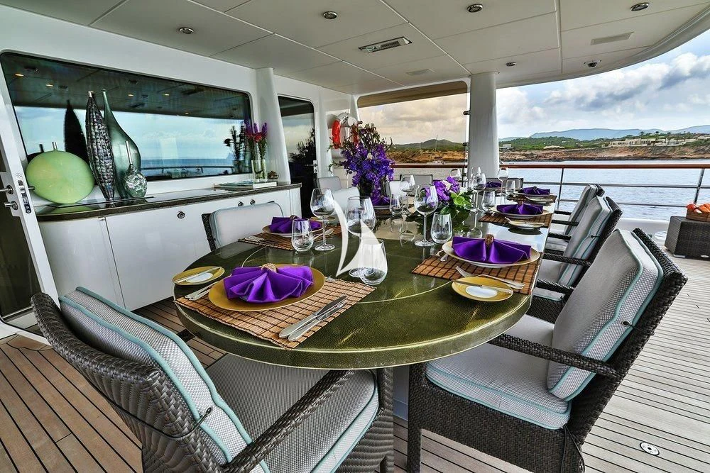 a table with plates and flowers on it aboard DENIKI Yacht for Sale