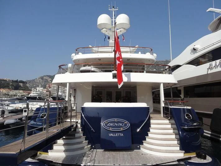 a large white boat with a red stripe on the front aboard DENIKI Yacht for Sale