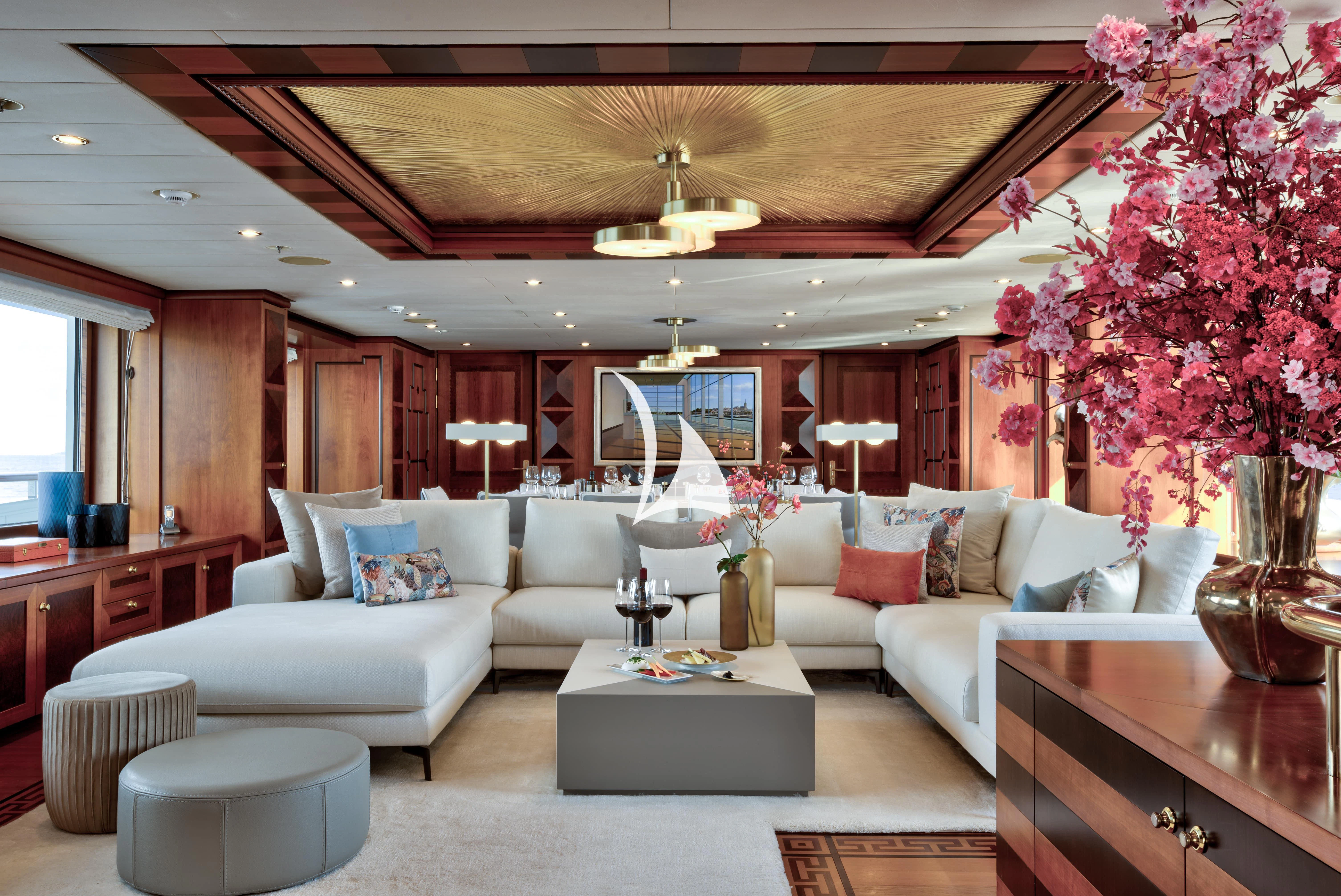 a living room with a large chandelier aboard DENIKI Yacht for Sale
