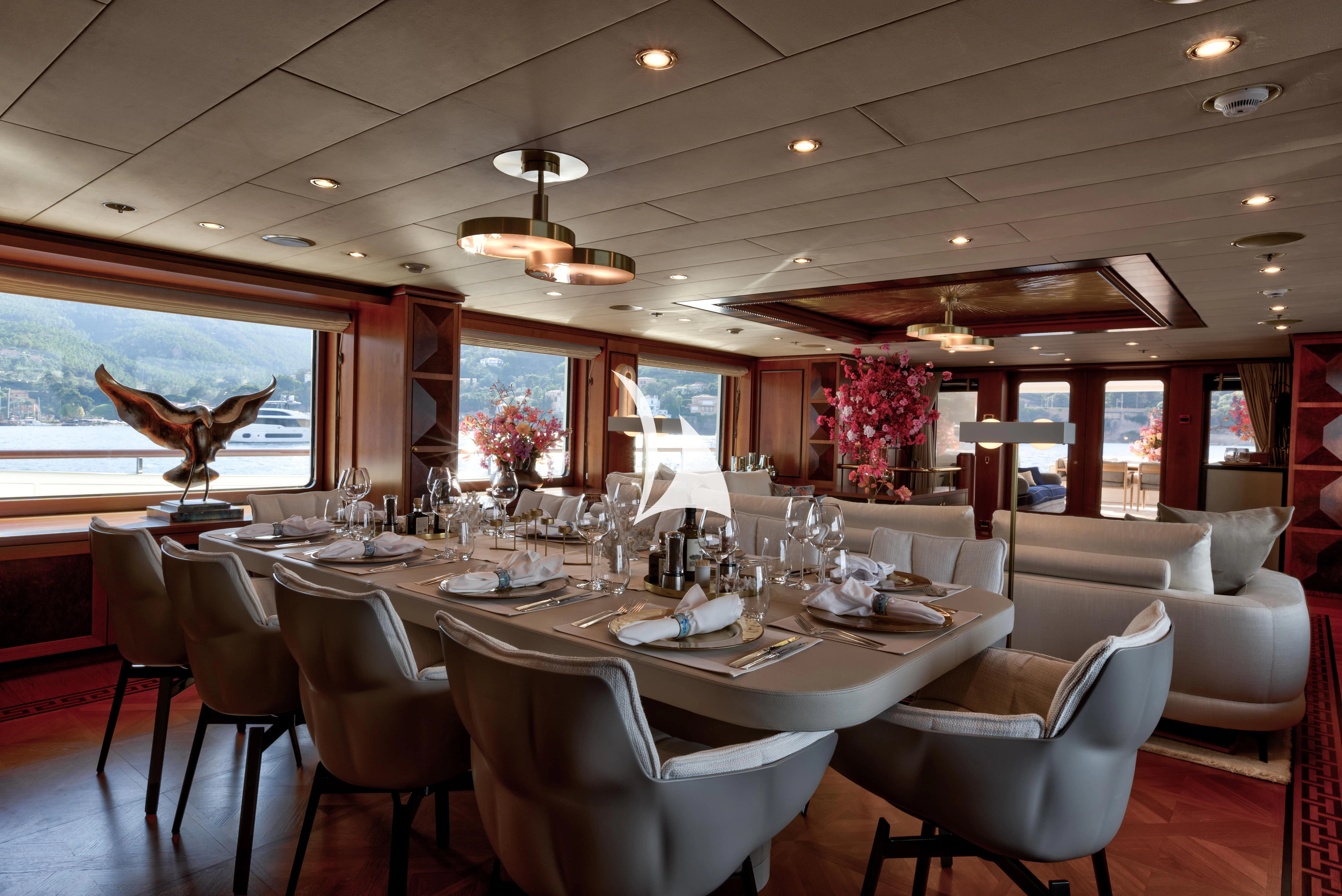 a dining room with a large table and chairs aboard DENIKI Yacht for Sale